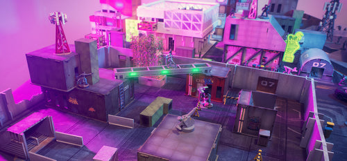 Colourful urban tabletop terrain with futuristic buildings and miniatures.