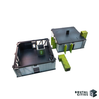 two 28mm terrain sci fi buildings painted black with green detailing and translucent windows. roof removed from one building