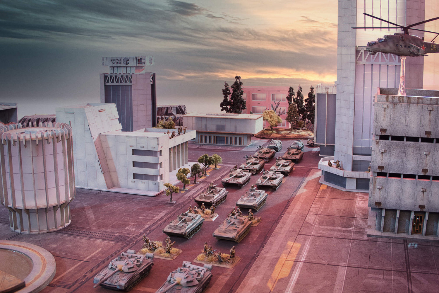 15mm team yankee soviet tanks and infantry parade down a street surrounded by large brutalist terrain buildings.
