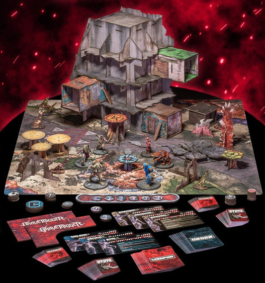 A tabletop display of a post-apocalyptic  tabletop gaming set, featuring a large detailed terrain mat with ruined buildings, tables, and monster miniatures, alongside numerous rulebooks, cards, dice, and tokens arranged on a black surface against a dramatic red glowing background.