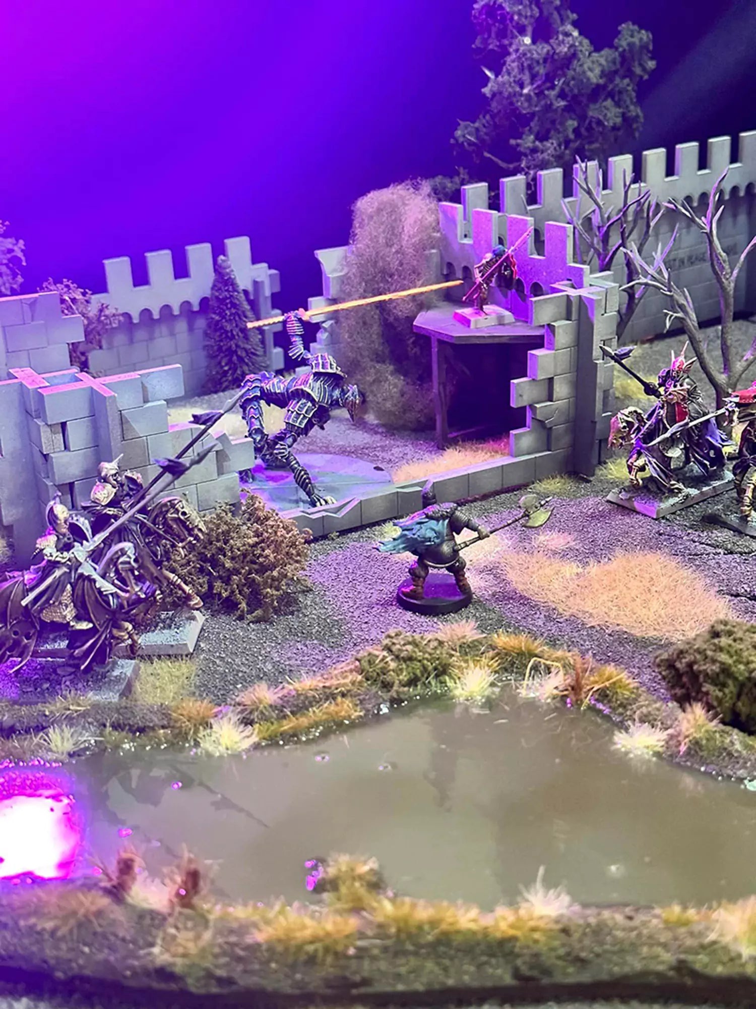 undead miniatures fighting amongst ruined wall terrain and a swamp