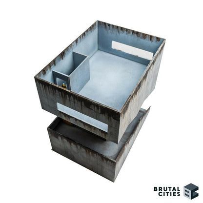 Interior view of brutalist wargaming terrain showing stairwell and 28mm miniature for scale.